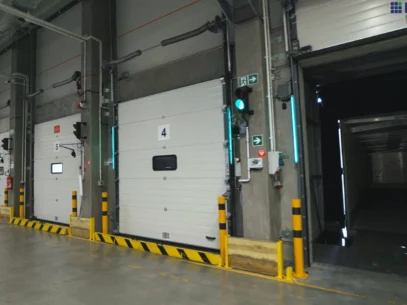 Drzwi ramp w centrum dystrybucyjnym, wyposażonych w paski LED poprawiające pracę załadunkowego.